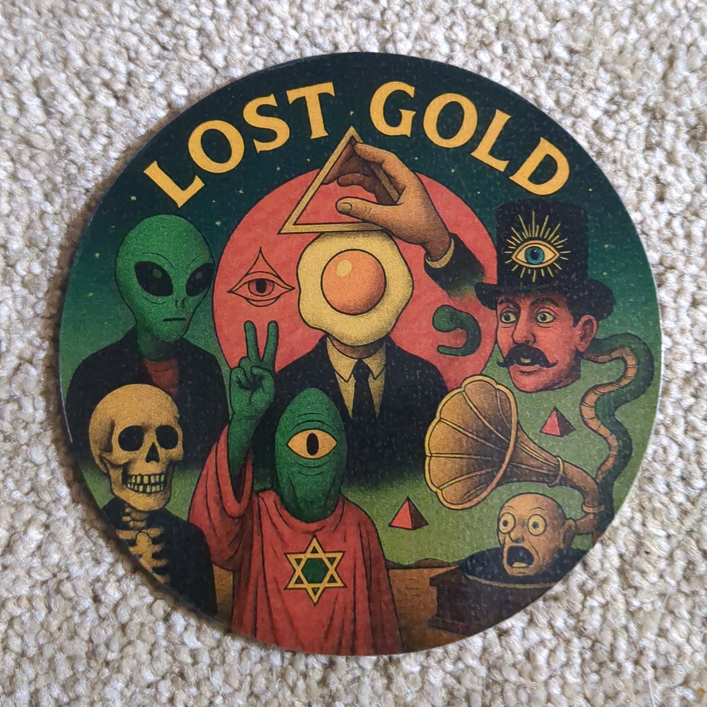 Round colorful sticker with 'Lost Gold' text and various designs on a textured surface